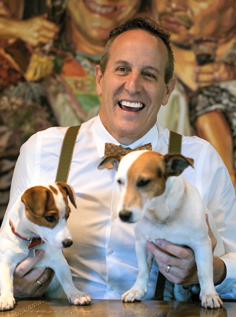 Bill Bensley smiling holding his two puppies