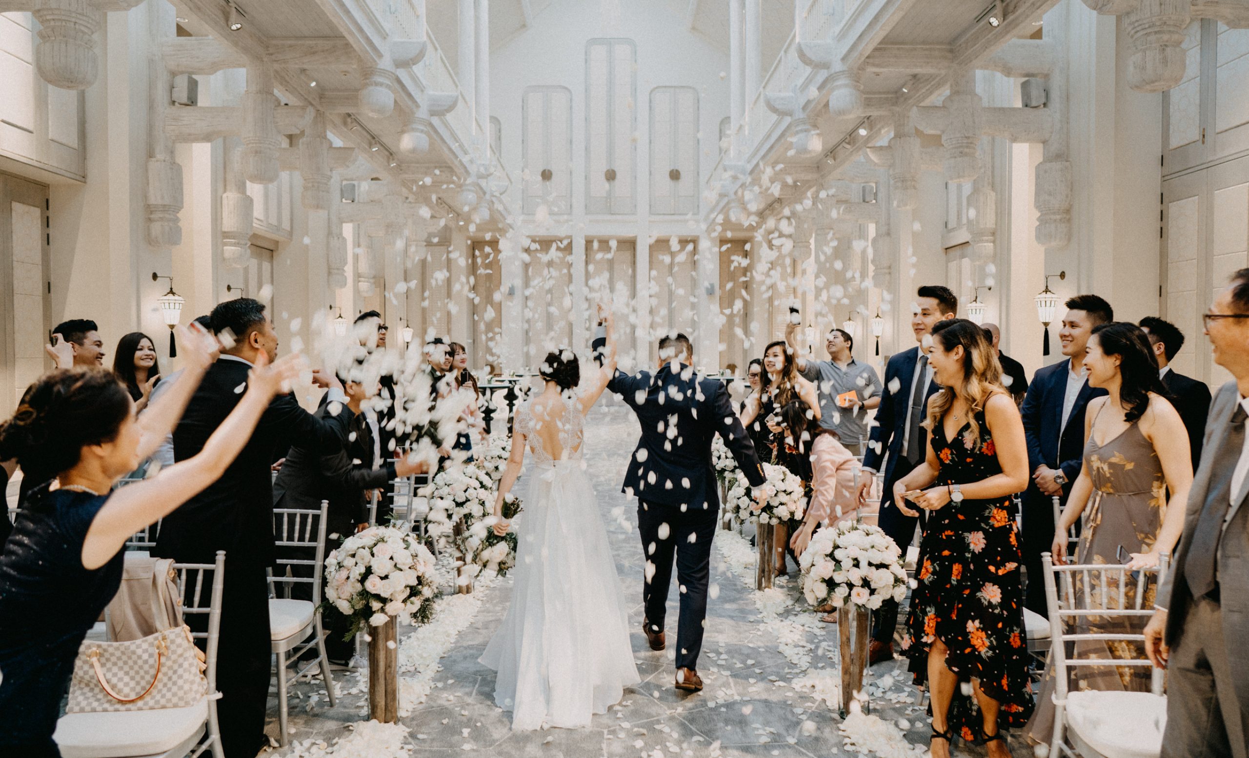 Groom and bride walking on aisle at Reception hall, surrounding by guests